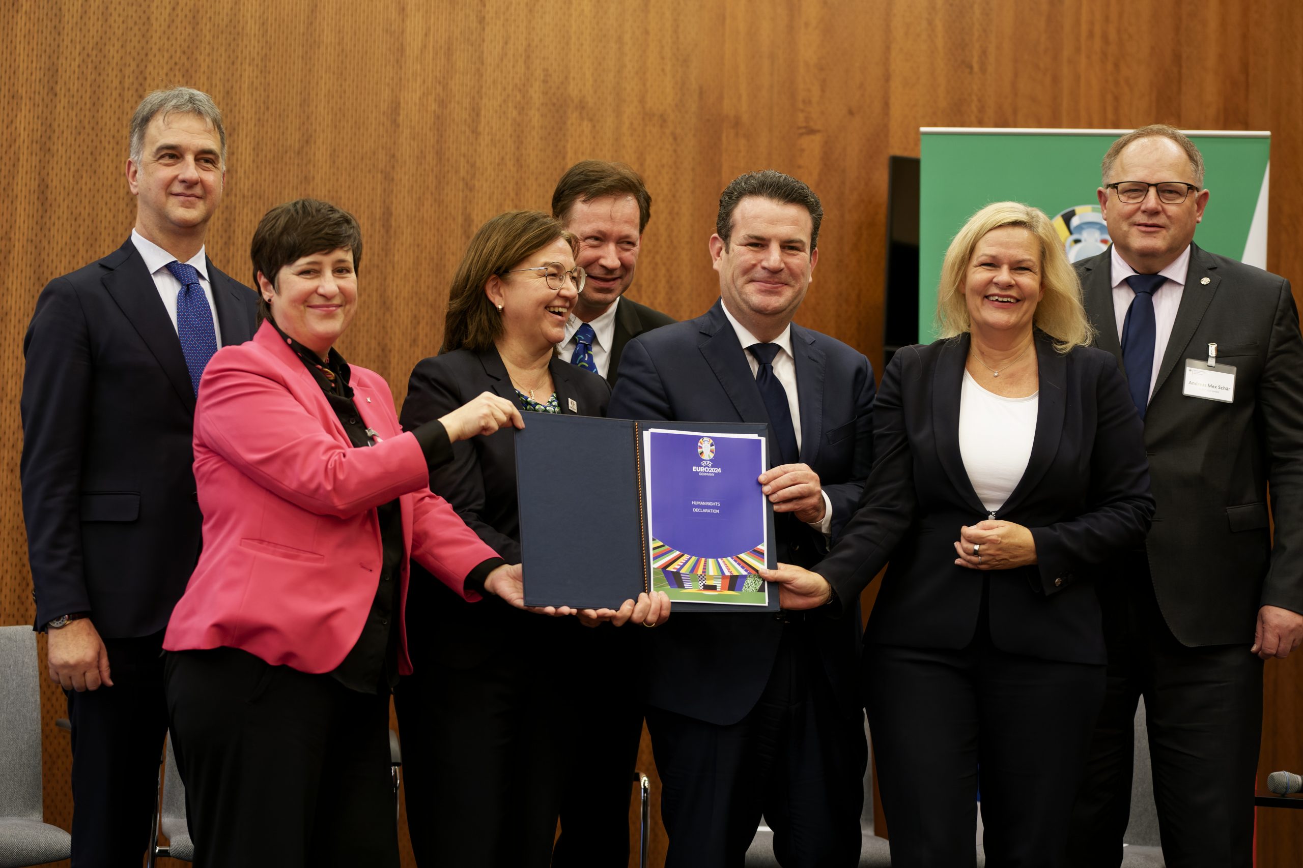 Bundesinnenministerin Faeser und Bundesarbeitsminister Heil sowie weitere Personen halten nach Unterzeichnung die Menschenrechtserklärung zur UEFA EURO 2024 hoch.